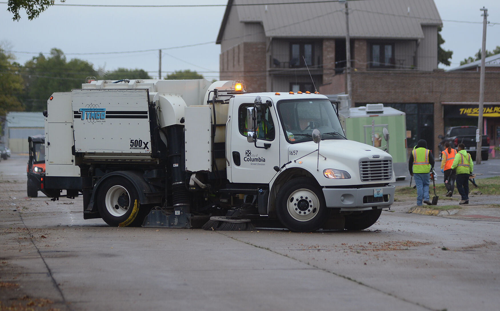 A street sweeper cleans up the remaining grass clippings